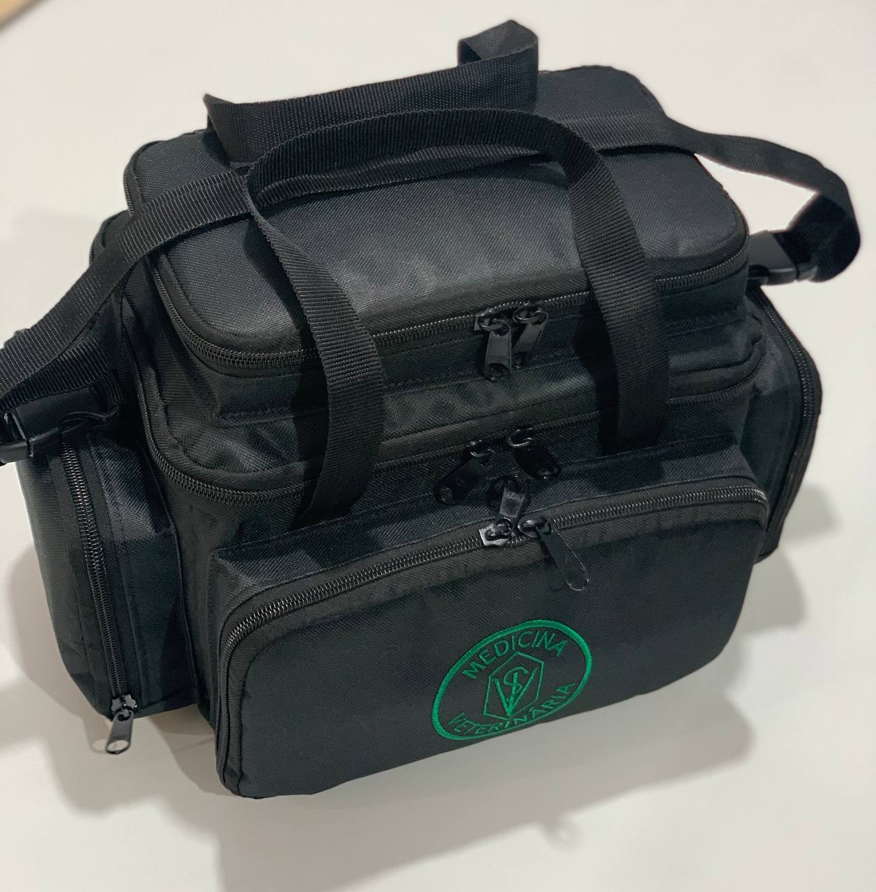 Bolsa profissional com a logo da medicina veterinária,  cor preta com alça e tira colo.