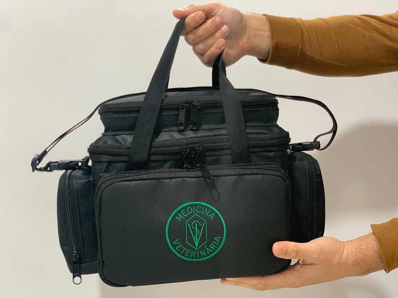 Bolsa profissional com a logo da medicina veterinária,  cor preta com alça e tira colo.