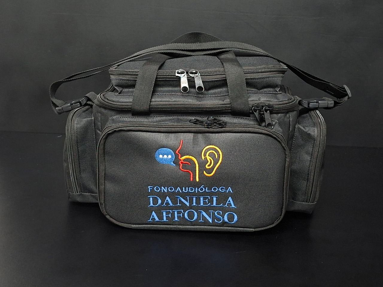 Bolsa profissional personalizada com a logo do cliente, cor preta com alça e tira colo.