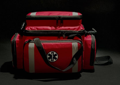 bolsa de APH. Imagem frontal, bolsa na cor vermelha, bordado da Cruz da Vida e faixas refletivas